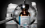 Vergroßerte Ansicht einer Flasche SkinCeuticals C E Ferulic mit verschiedenen Hautpflegeprodukten im Hintergrund.