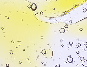 Des gouttes d&aposeau et des bulles d&aposair se formant dans un liquide jaunatre, creant un effet translucide et lumineux.