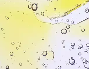 Des gouttes d&aposeau et des bulles d&aposair se formant dans un liquide jaunatre, creant un effet translucide et lumineux.