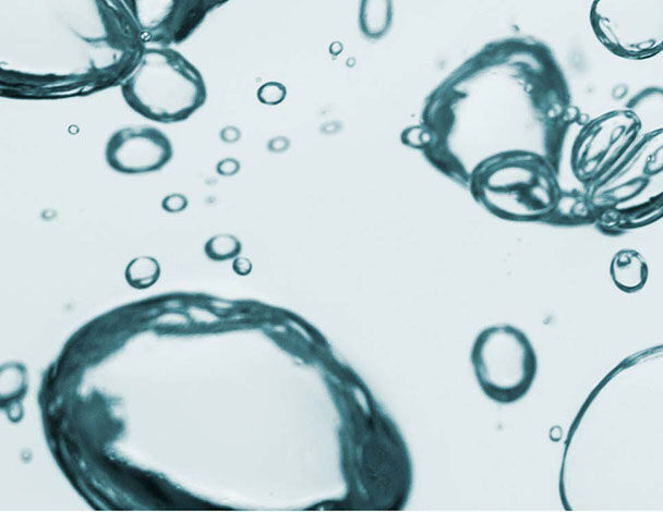 Bubbles d'eau flottant dans un liquide clair, creant un effet de texture apaisant et dynamique.