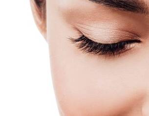 Gros plan sur un oeil feminin, mettant en valeur des cils longs et un teint lumineux.