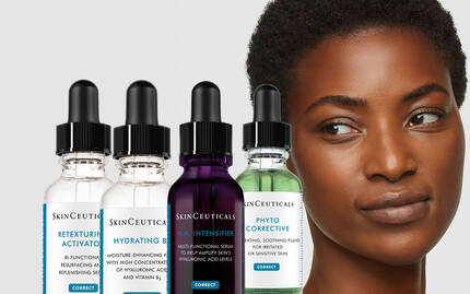 Une femme avec une peau eclatante, regardant vers la droite, a cote de flacons de serum de la marque SkinCeuticals.