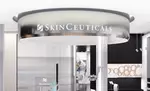 Enseigne suspendue de SkinCeuticals dans un espace moderne, refletant un environnement esthetique et professionnel.