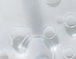 Gouttes d'eau et bulles sur une surface blanche, creant un effet de transparence et de legerete.