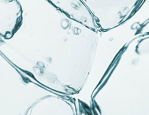 Gros plan sur des glacons transparents avec des bulles d’air en suspension dans l’eau, creant un effet visuel rafraichissant.