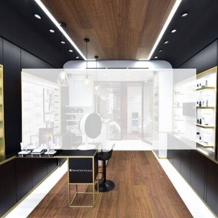 A modern skincare store interior featuring product displays on shelves, a central mirror, and informative wall texts in both English and French.