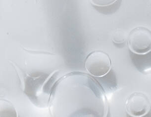 Bulles d'air flottant a la surface d'un liquide clair, creant une texture visuelle delicate.