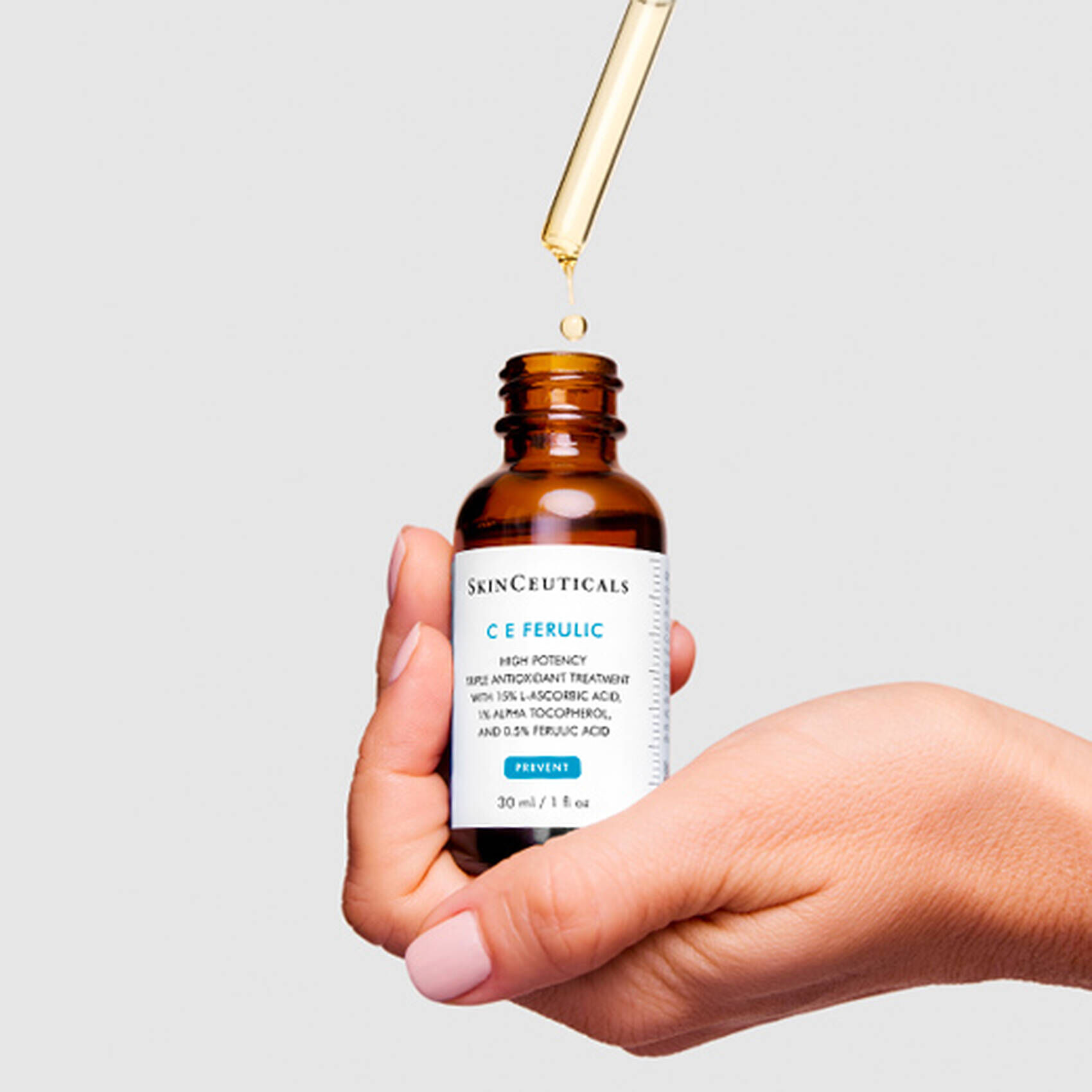 Flacon de serum C E Ferulic de SkinCeuticals, avec une pipette en train de liberer quelques gouttes.