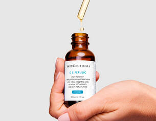 Flacon de serum C E Ferulic de SkinCeuticals, avec une pipette en train de liberer quelques gouttes.