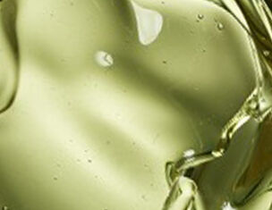 Gros plan sur une texture d'huile verte translucide, refletant la lumiere.