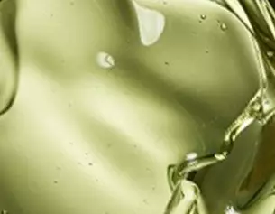 Gros plan sur une texture d&aposhuile verte, lumineuse, et fluide, evoquant l&aposonctuosite d&aposun produit naturel.