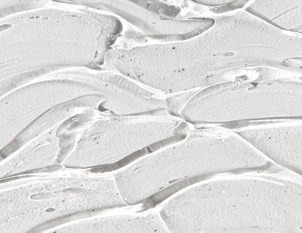 Close-up of a smooth, glossy white surface with flowing, wavy patterns resembling liquid or gel textures.