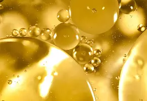 Bulles dorees et spheres lumineuses flottent dans un liquide vibrant, creant un effet visuel captivant.