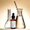 Un flacon de serum SkinCeuticals "Silymarin CF" avec des flacons et un tube en verre, le tout sur un fond lumineux.