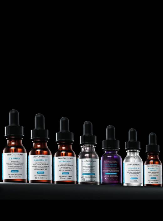 Trois flacons de serum avec compte-gouttes sur fond noir, chacun etiquete avec des inscriptions distinctes.