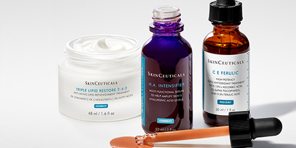 Des flacons de serums de soins de la peau disposes de maniere artistique sur un fond blanc.