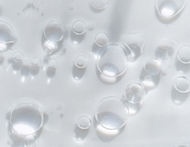 Gouttes d'eau claires et bulles d'air flottant a la surface d'un liquide, creant un effet translucide.
