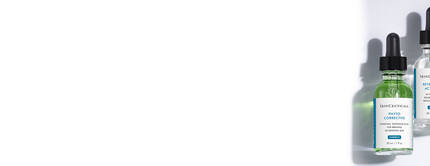 Quatre flacons de serums de soins de la peau sur fond blanc, chacun avec une etiquette indiquant son nom et ses ingredients.