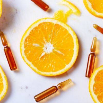 Des tranches d'orange fraiche entourees de petites ampoules en verre.