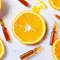 Des tranches d'orange fraiche entourees de petites ampoules en verre.