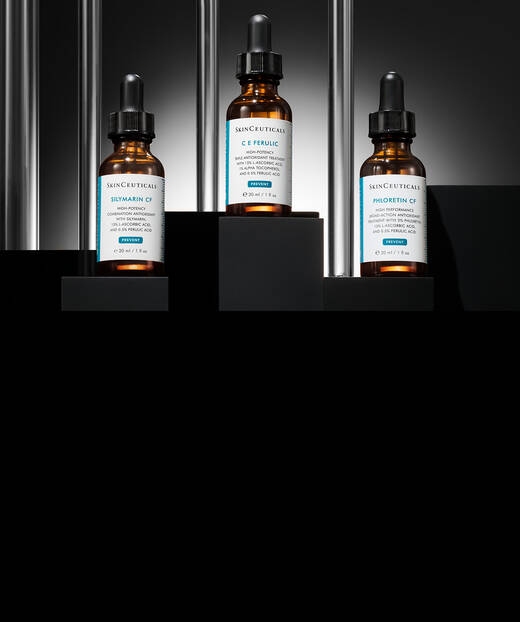 Trois flacons de serum avec compte-gouttes sur fond noir, chacun etiquete avec des inscriptions distinctes.